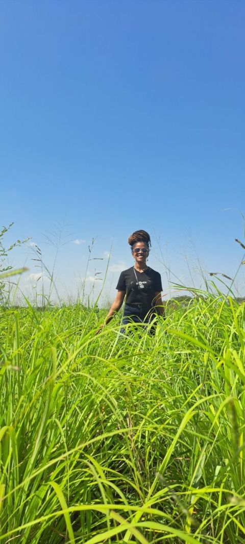 Lemongrass Farming in Kenya 2026 - The Complete Commercial Profit Guide for Essential Oil and Tea Production 3 A young lady farmer proudly poses at her thriving lemongrass farm, demonstrating the success achievable through dedicated lemongrass farming in Kenya.