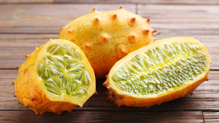 A ripe whole thorn melon displayed next to a sliced fruit revealing the green jelly-like flesh and edible seeds, demonstrating the quality and ripeness achieved in commercial thorn melon farming in Kenya.