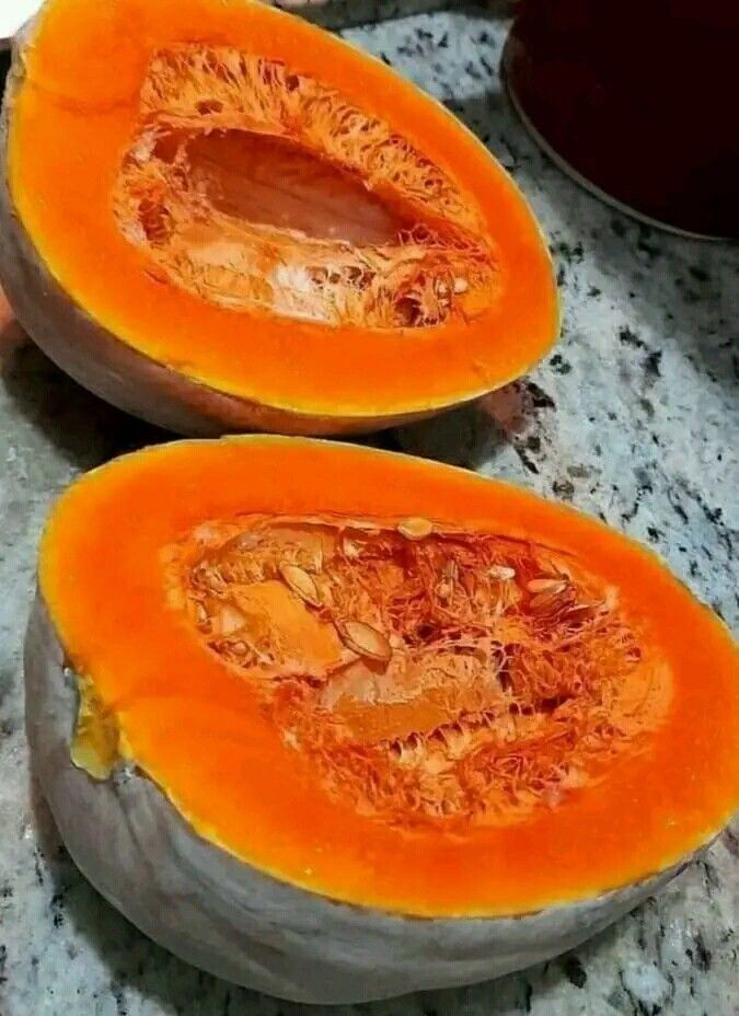 A freshly sliced pumpkin showing the bright orange flesh, demonstrating the quality and ripeness achieved through proper curing in pumpkin farming in Kenya.